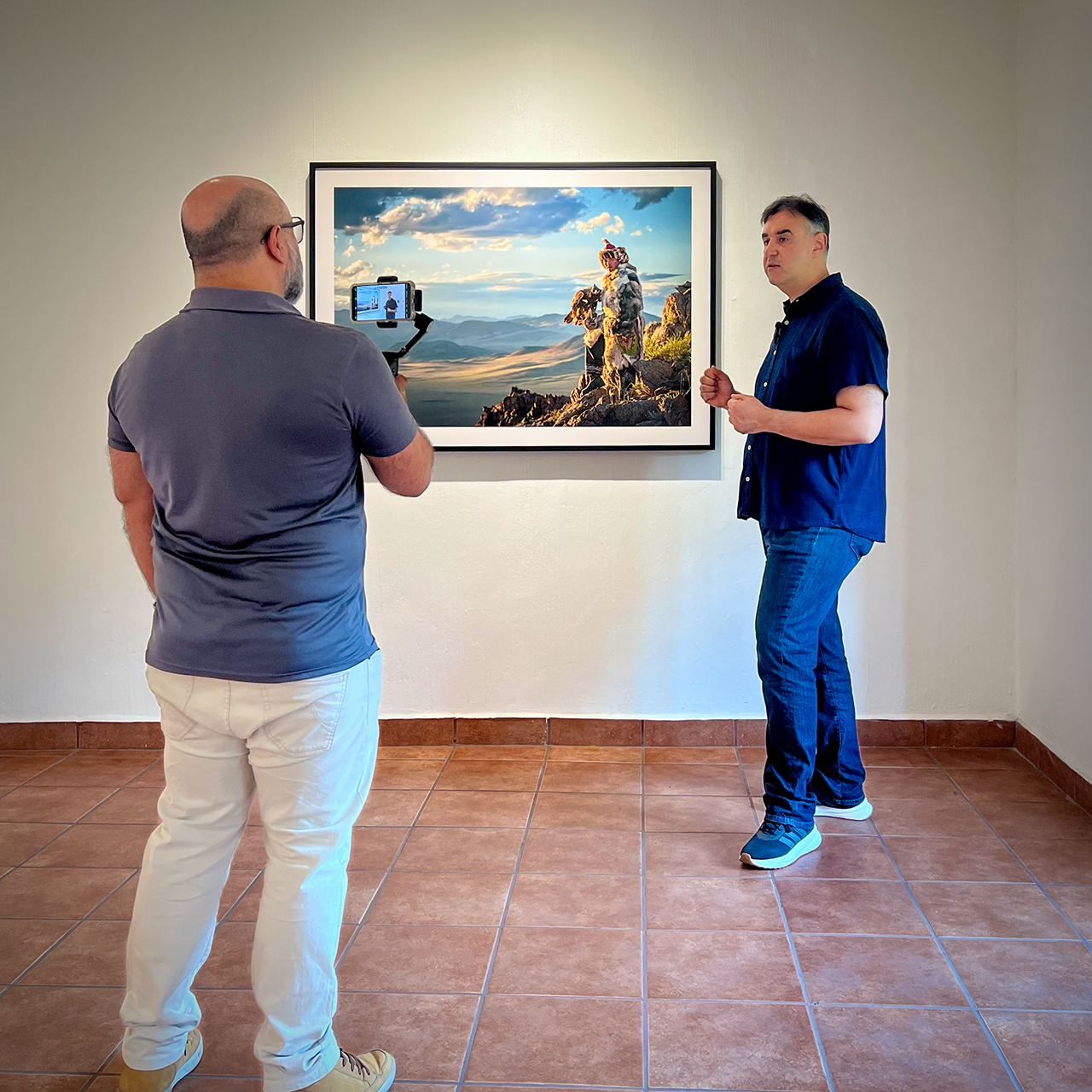 Guillermo Campos filme Philippe Paquet à côté d’une photographie de chasseur à l’aigle